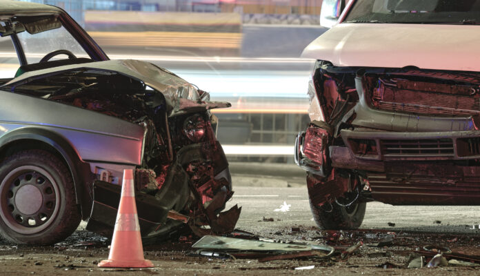 Cars crashed heavily in road accident after collision on city street at night. Road safety and insurance concept